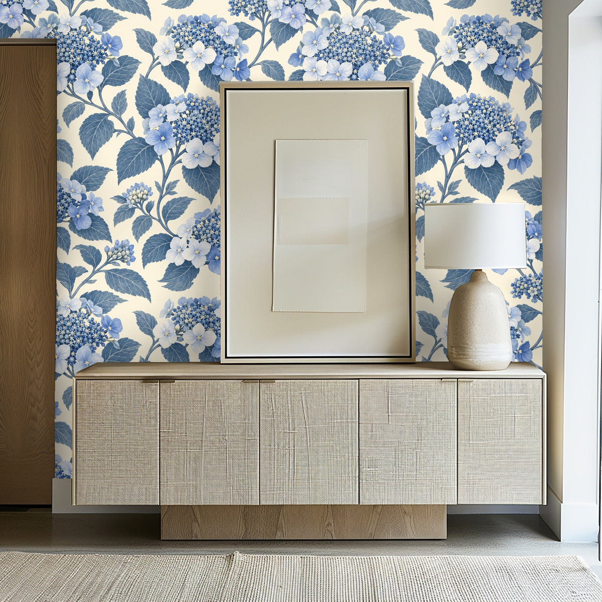 Close-up detail of painterly blue hydrangea clusters and textured leaves on a warm cream background