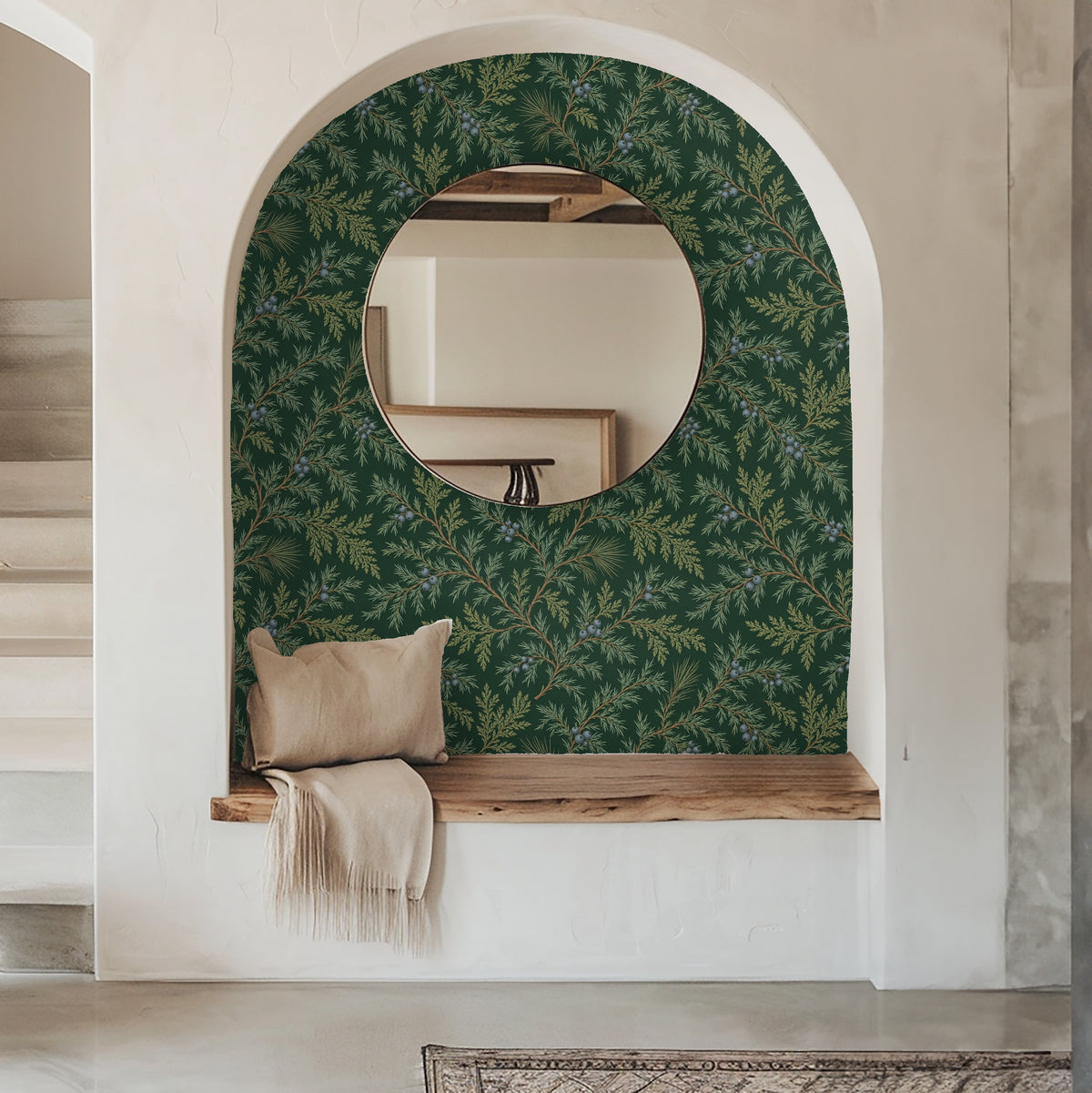 Narrow arched entryway lined in Juniper Drift wallpaper with round mirror and bench, showcasing the pattern at human scale