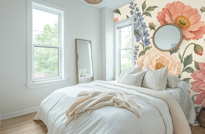 Bright bedroom where the floral mural is used as a headboard wall, with neutral linens and a round mirror hung on the pattern.