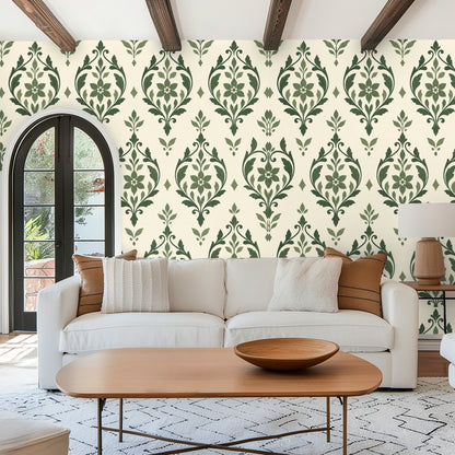 Bedroom wall with green upholstered bedframe and sage arabesque wallpaper behind the bed