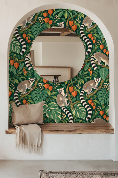 Wallpaper detail showing three ring-tailed lemurs perched in lush green foliage with orange lantern-like flowers.