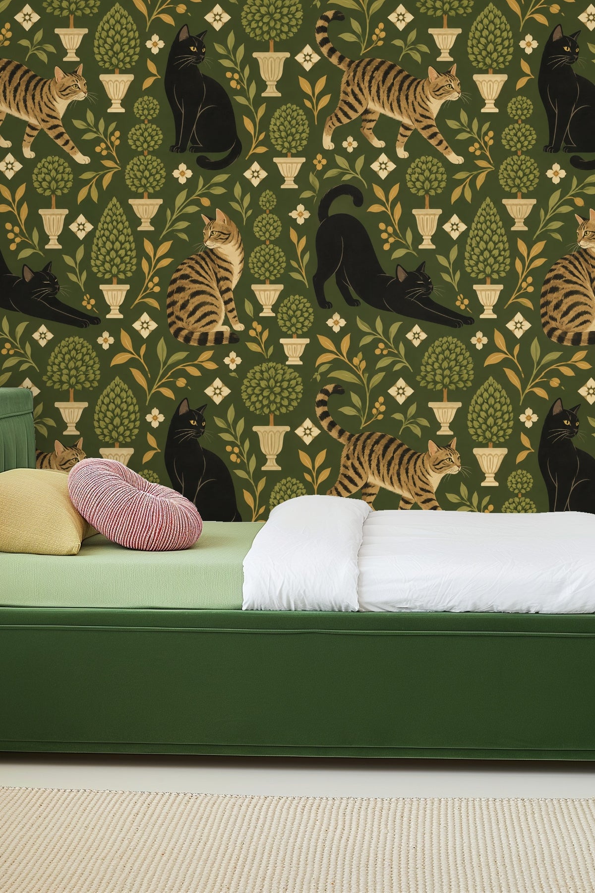 Living room scene showing olive green wallpaper with cat and plant motif behind curved white sofa and red chair