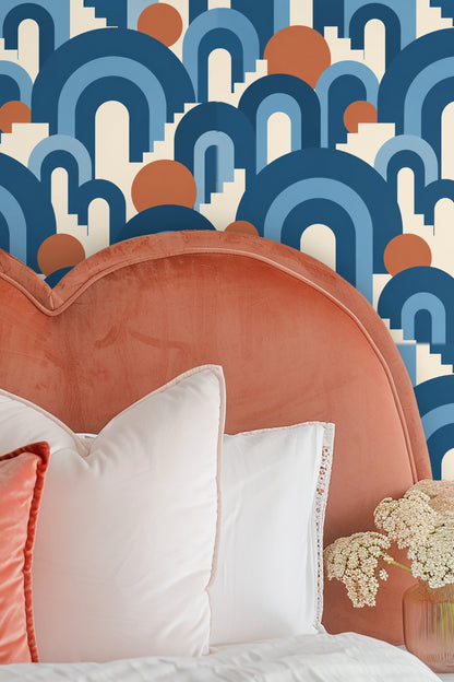 Close-up of bold graphic wallpaper with blue stepped arches and terracotta circles on ivory background.