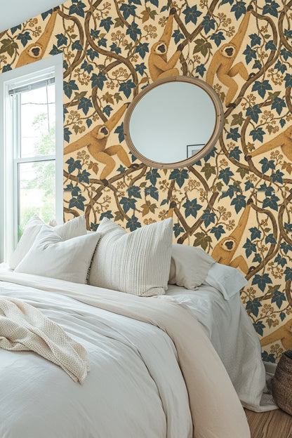 Close-up of a living room wall covered with golden gibbons and ivy wallpaper, paired with pink sofa and peach cushion