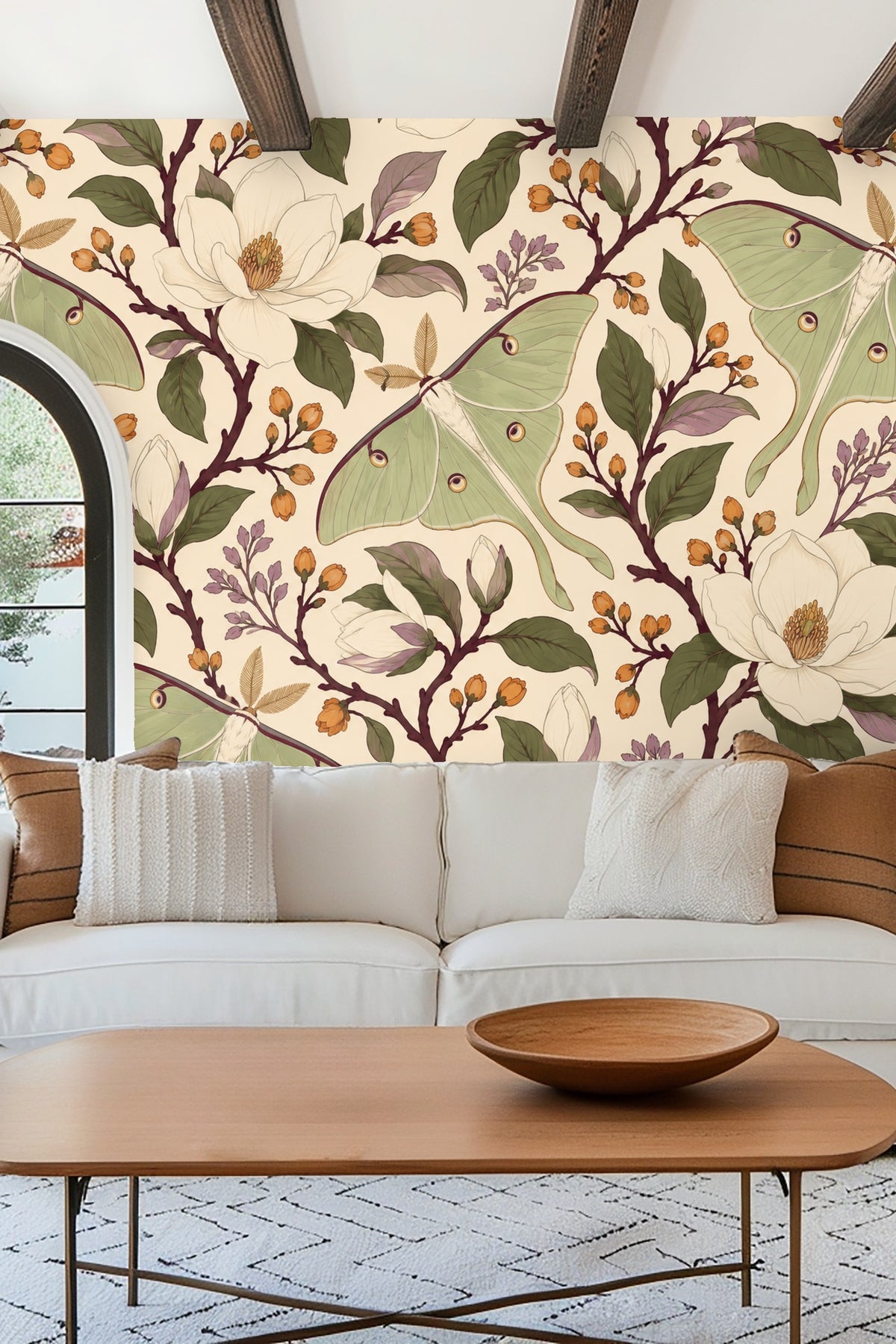 Bedroom wall with Moon Moth Magnolia wallpaper behind a cream upholstered headboard and soft pink pillows