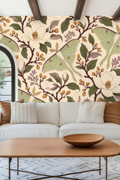 Bedroom wall with Moon Moth Magnolia wallpaper behind a cream upholstered headboard and soft pink pillows