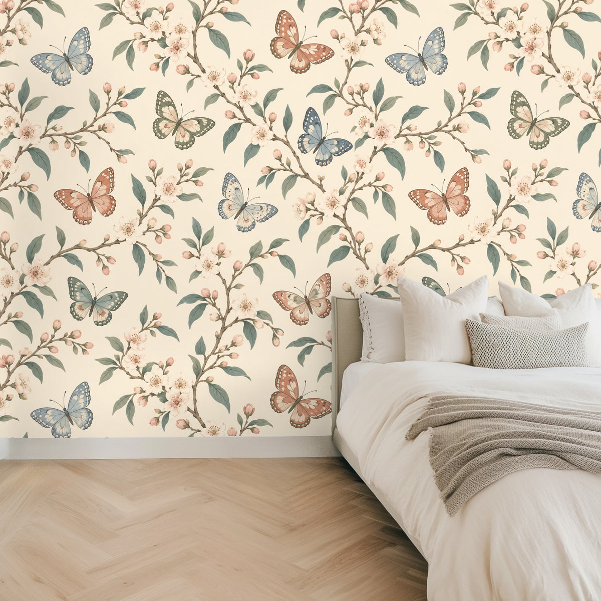 Close-up of Porcelain Flutter wallpaper showing butterflies, cherry blossoms and muted sage leaves on a warm cream background