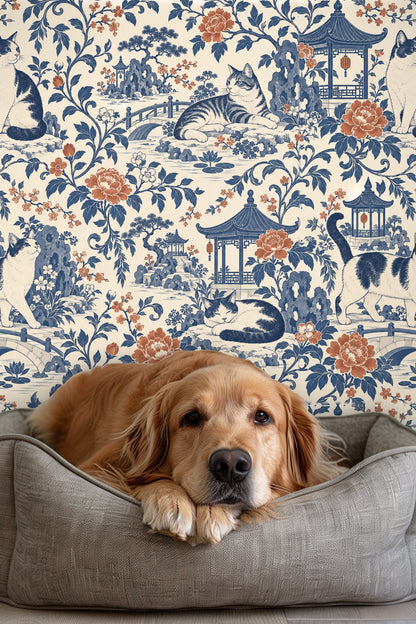 Dog resting in bed in front of wallpaper featuring cats and garden scene in blue and terracotta