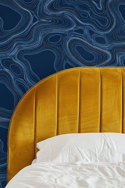 Green bed against wall covered with indigo and blue engraved line wallpaper