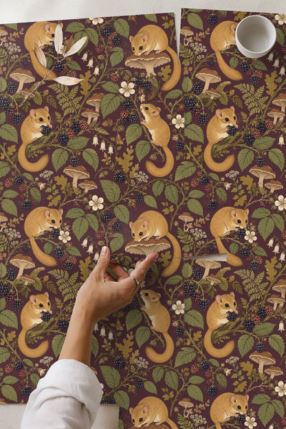 Living room close-up showing plum wallpaper with dormice and blackberry motifs behind a white sofa with pillows