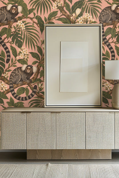 Wallpaper pattern with three marmosets perched on leafy branches against a pink background