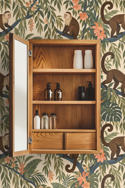 Wallpaper pattern focusing on curving blue branches and green, orange, and peach botanical elements surrounding capuchin monkeys