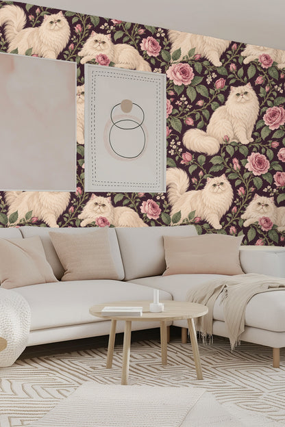 Close-up of a cream Persian cat sitting among pink roses and green leaves on plum wallpaper