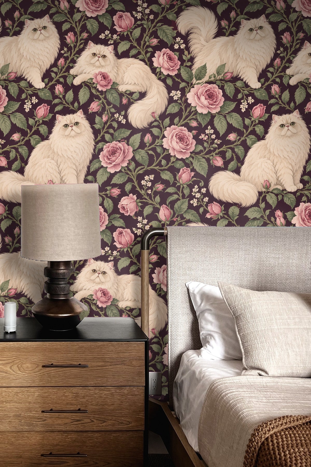 Living room feature wall with Persian Rose Cats wallpaper, green velvet round stool, and terracotta cushions on beige sofa