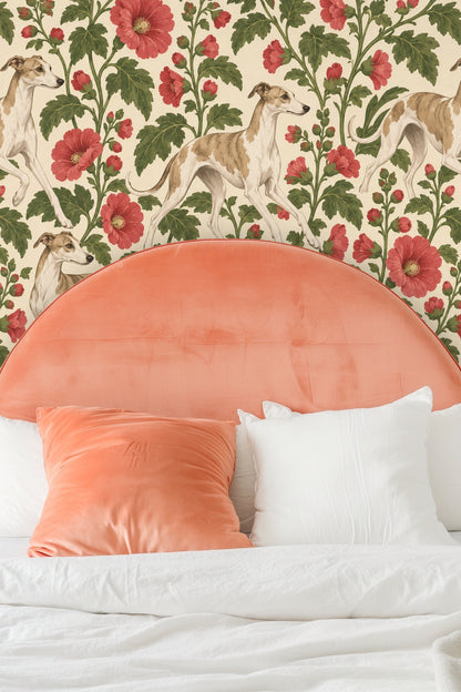 Bedroom with peach velvet rounded headboard, matching pillow, and wallpaper featuring greyhounds and red hollyhocks