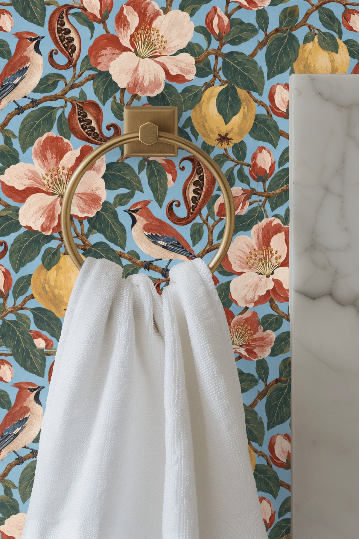Close view of Quince & Waxwing wallpaper showing detailed floral and bird motifs behind a lit candle and flower arrangement on wooden table