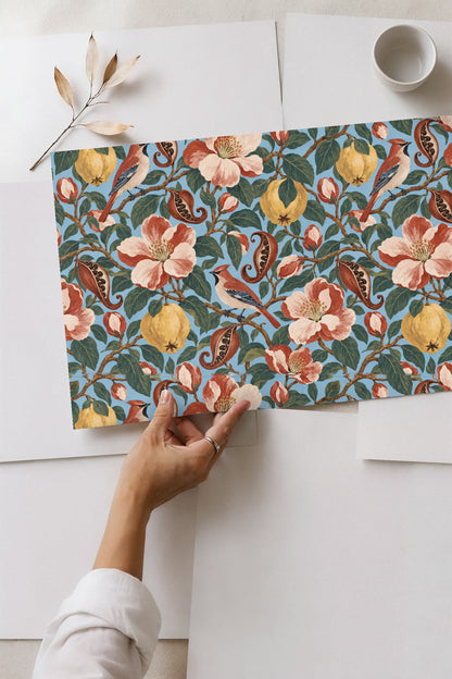 Pattern repeat showing clusters of leaves, buds, flowers, birds, and fruits on blue backdrop