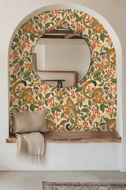 Wallpaper pattern showing three small monkeys with orange tails climbing on green vines with red and cream honeysuckle flowers on a cream-be