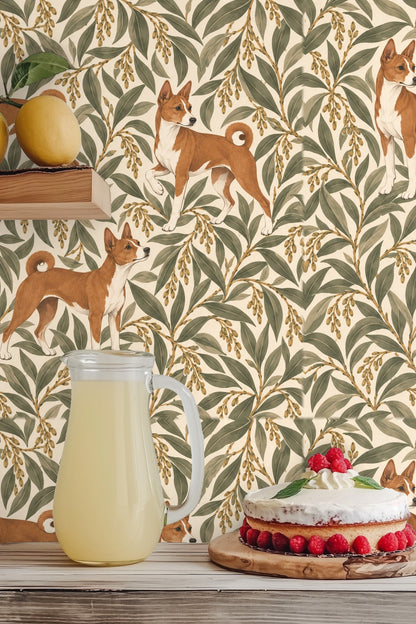 Sculptural lamp and wooden table contrasted against richly patterned dog and leaf wallpaper