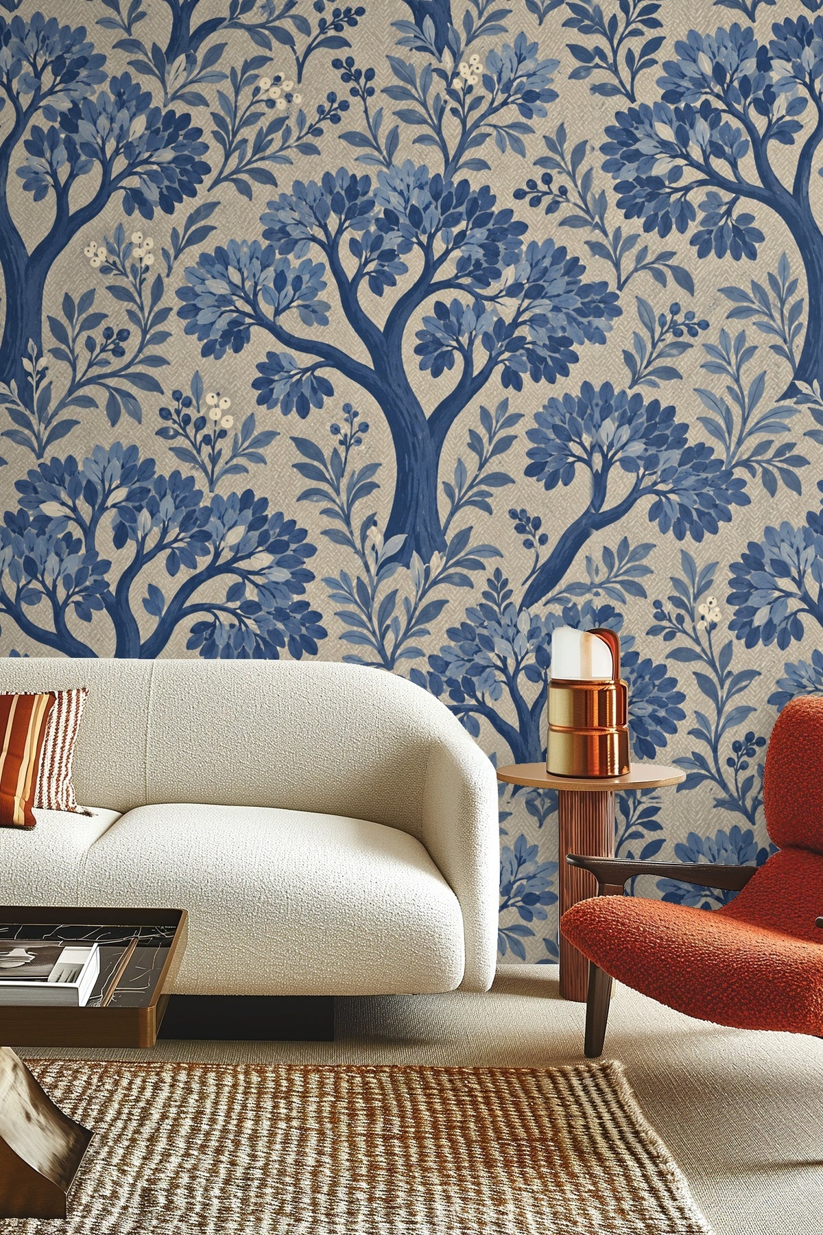 Living room with cream sofa and wooden table against wallpaper with blue leafy trees and herringbone texture