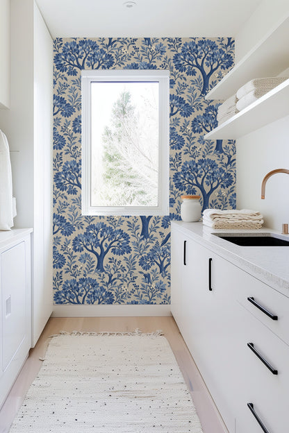 Cluster of leafy branches in various blue tones with small berries on wallpaper