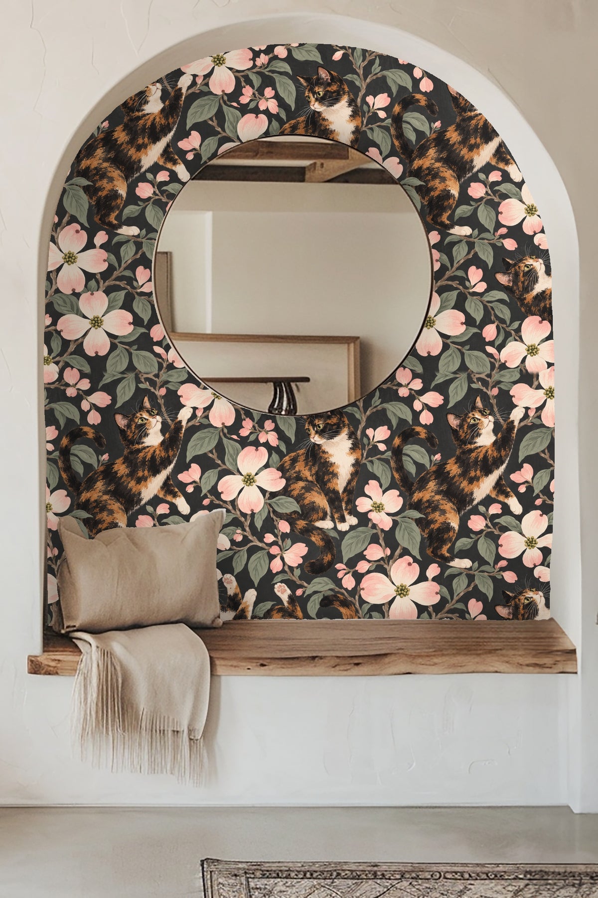 Bedroom styled with boho decor in front of calico cat and dogwood floral wallpaper.