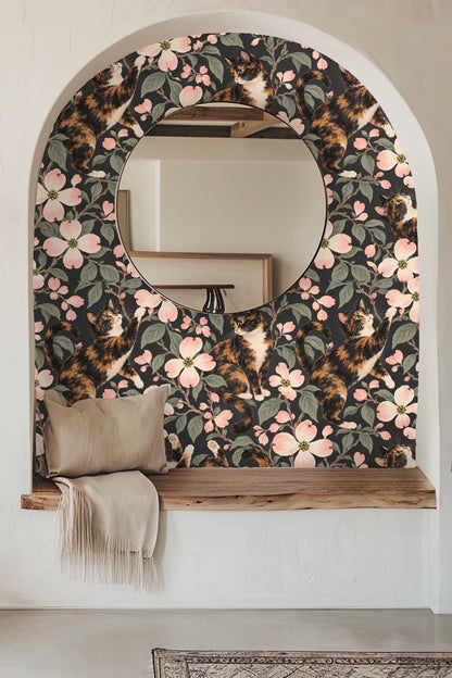 Bedroom styled with boho decor in front of calico cat and dogwood floral wallpaper.