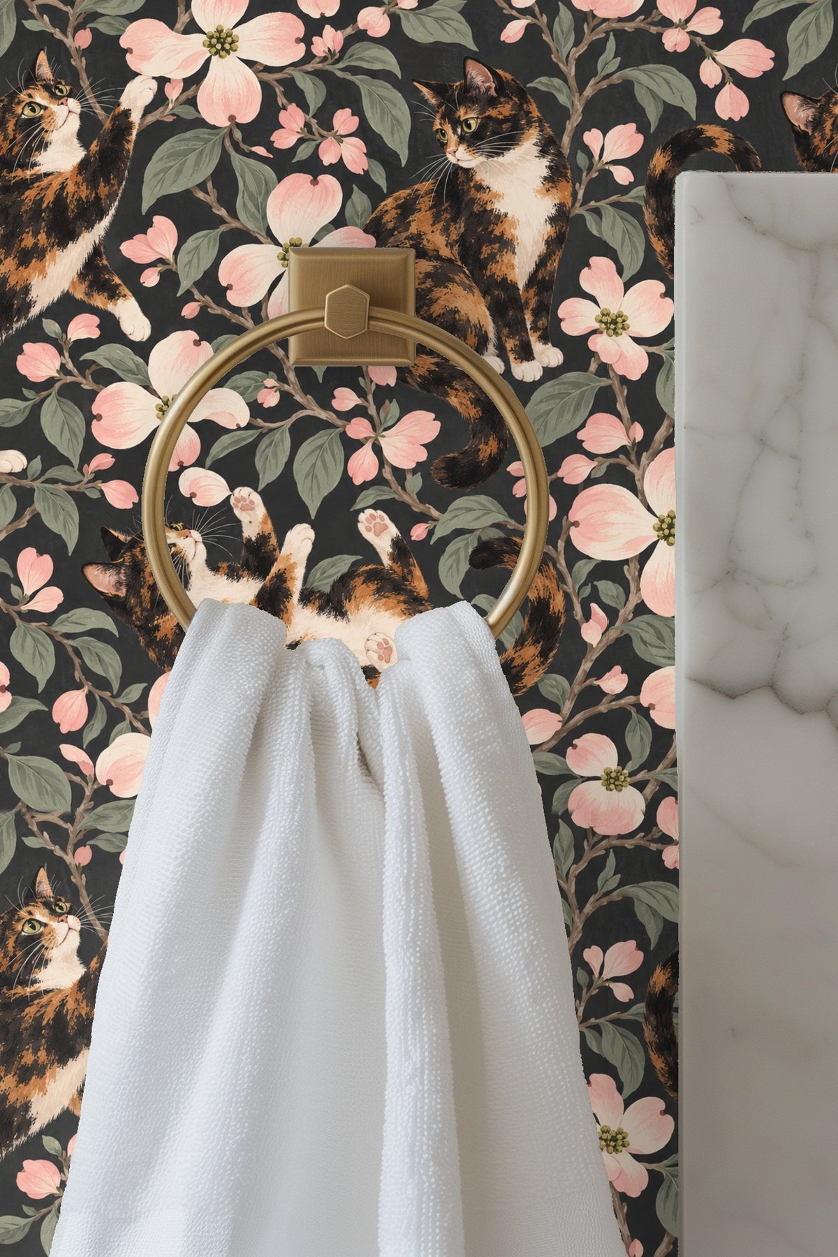 Close-up of a calico cat lounging amid dogwood flowers on wallpaper.