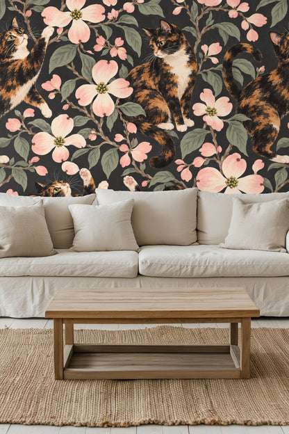 Living room wall featuring wallpaper with calico cats and dogwood flowers next to a wooden ladder with a blanket.