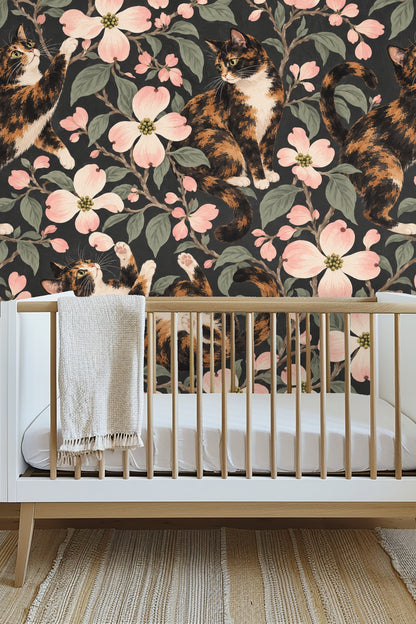Cozy bedroom with large wallpaper mural of calico cats and blush dogwoods behind wood furniture.