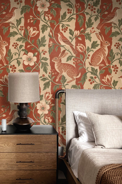 Detail of singing bird perched on leafy vine with red berries on wallpaper