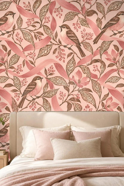 Living room with wallpaper featuring birds on leafy branches with pink ribbons, curved pink sofa, and neutral chair.