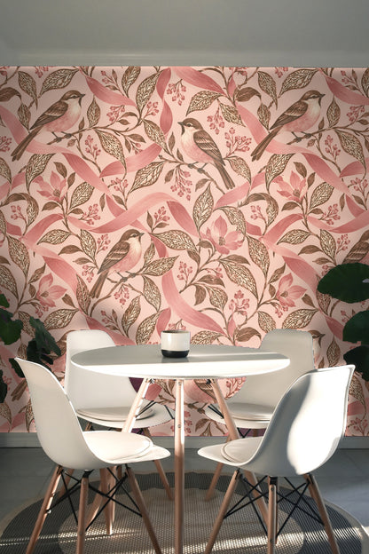 Partial view of a living room wall with pink bird wallpaper, pink velvet sofa, and round marble table.