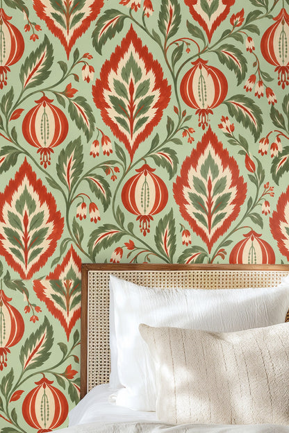 Soft cream throw pillows in front of wallpaper with painterly orange lantern and leafy design.