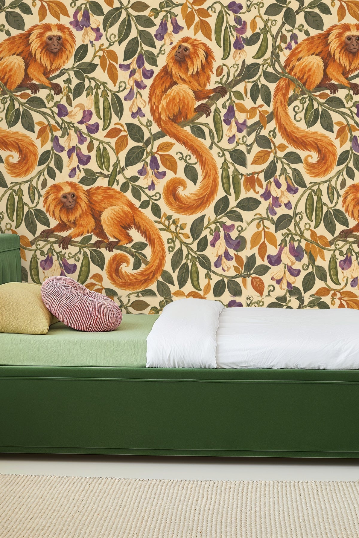 Bedside with mustard velvet headboard against monkey and leaf wallpaper