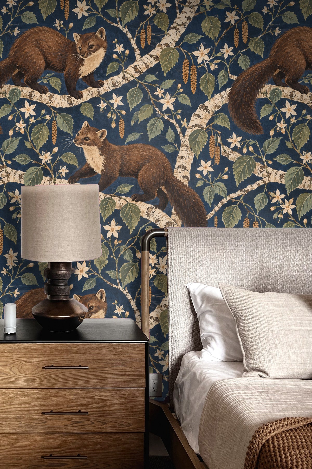 Atmospheric view of a blue floral and animal wallpaper in a modern living room with mid-century furniture and warm-toned carpet.