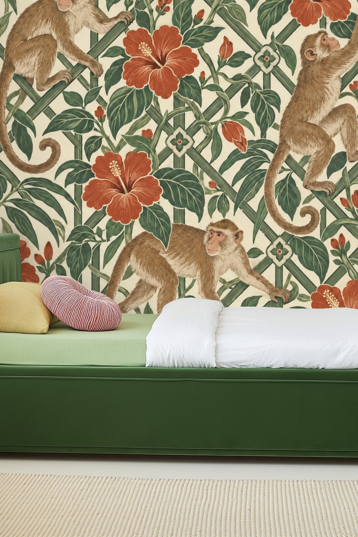 Living room with mazeleaf macaques wallpaper behind orange couch and terracotta rug, with natural light