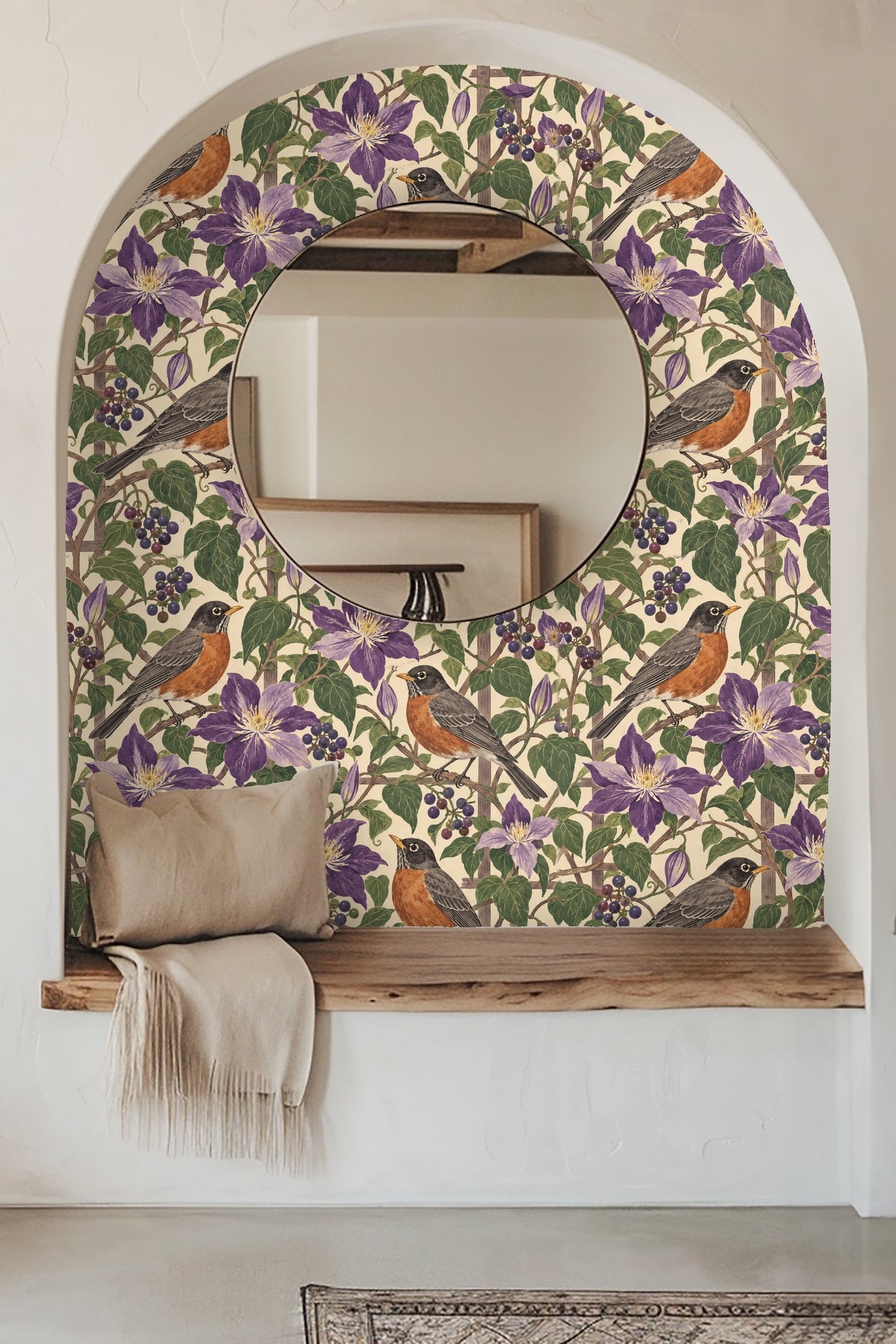 Close-up view of wallpaper with violet clematis flowers, robins, and berry clusters accented by a lit candle and flowers