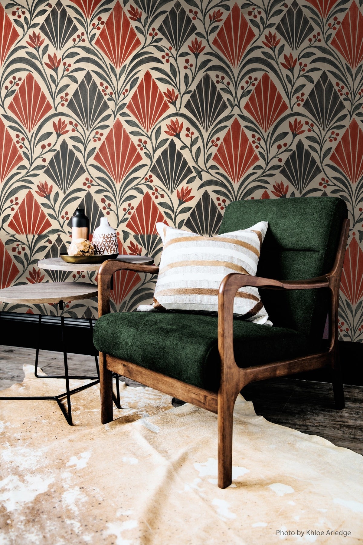 Red flower buds peek between geometric fans in wallpaper pattern