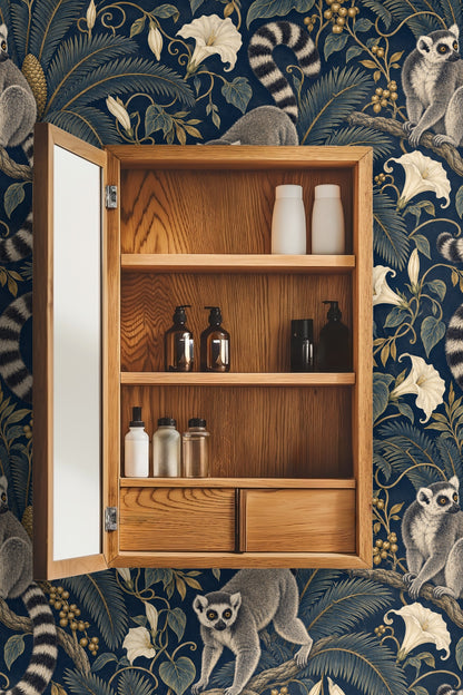 Close detailed segment of the wallpaper showing lemur faces and striped tails intertwined with botanical elements in gold and cream.