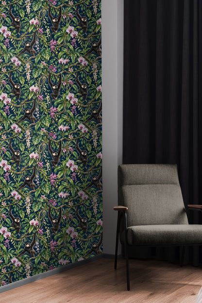 Bedroom with green bedframe and navy wallpaper mural depicting gibbons swinging among leafy vines and orchids