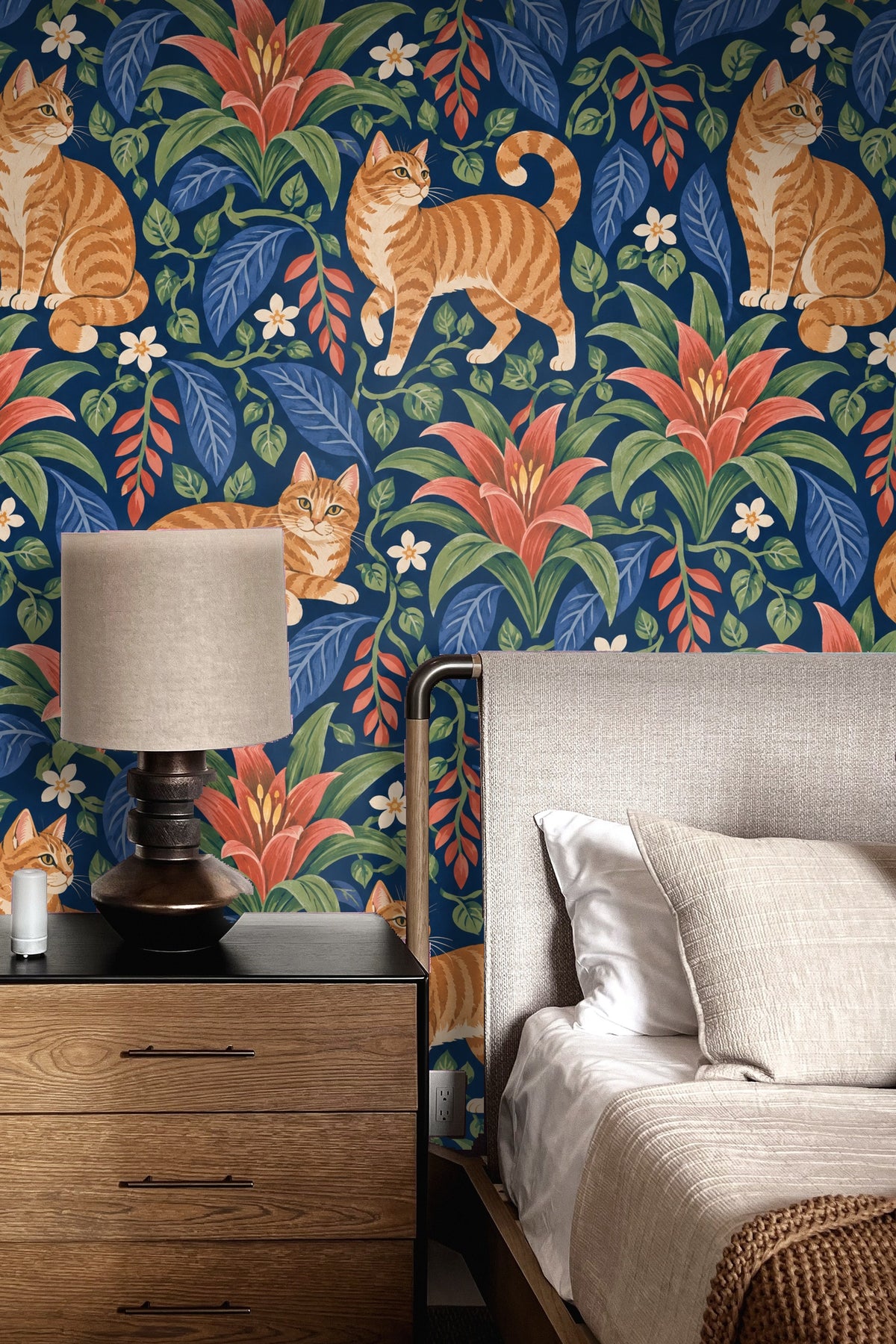 Wallpaper pattern with ginger tabby cats and red bromeliad flowers on indigo background