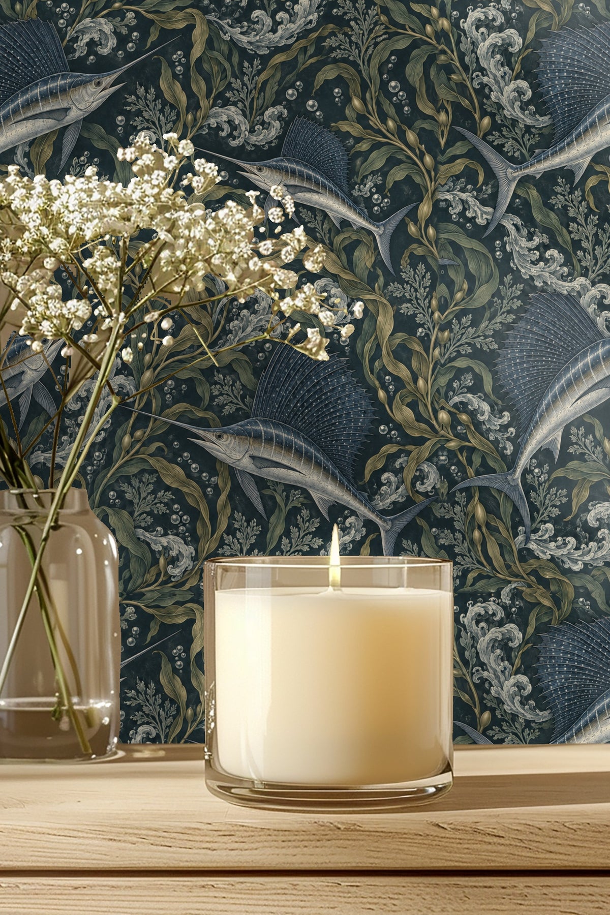 Bathroom vanity with brass fixtures and wallpaper featuring sailfish and swirling water design.