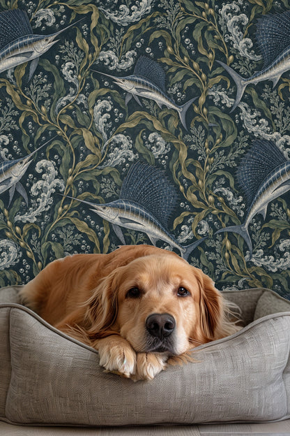Golden retriever lying on bed in front of wallpaper with blue sailfish and seaweed pattern.