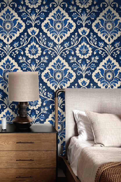 Living room featuring cobalt velvet damask wallpaper behind a cream rounded sofa and orange vintage chair.