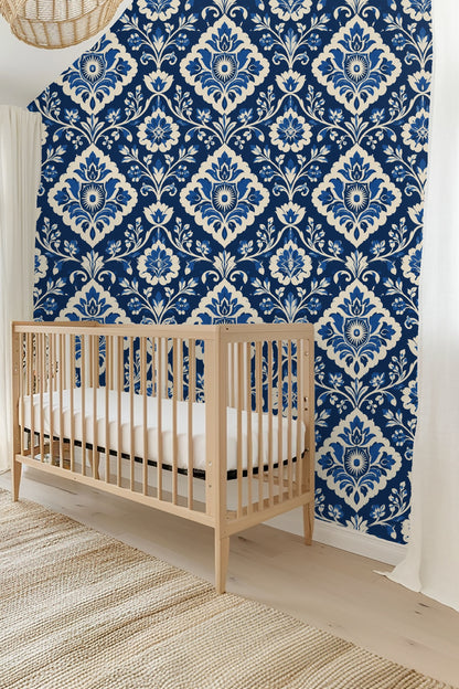 View of bedroom wall with wallpaper behind bedside lamp and pillow cushions.