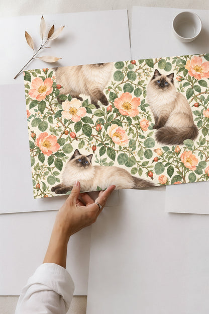 Wallpaper pattern showing repeated arrangement of three ragdoll cats and floral clusters