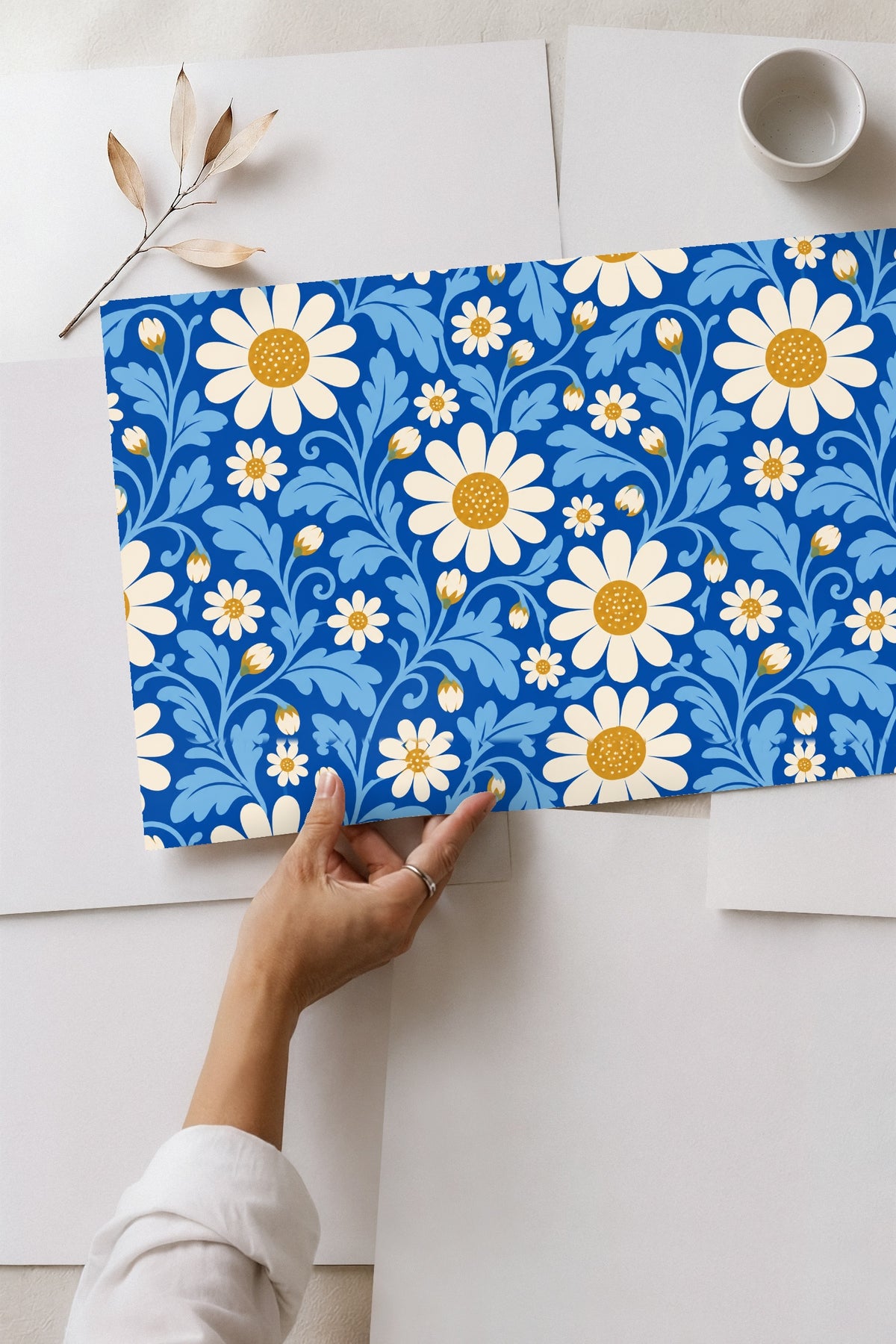View of wallpaper edge meeting white baseboard below blue patterned wall