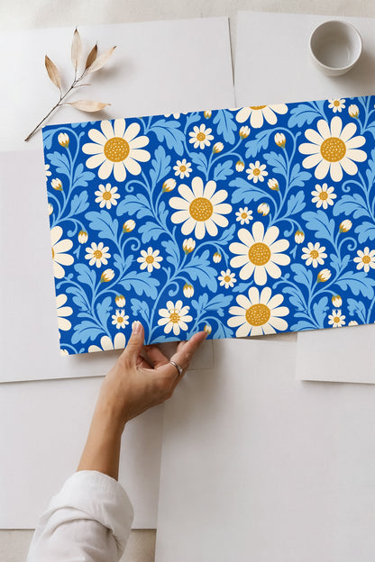 View of wallpaper edge meeting white baseboard below blue patterned wall