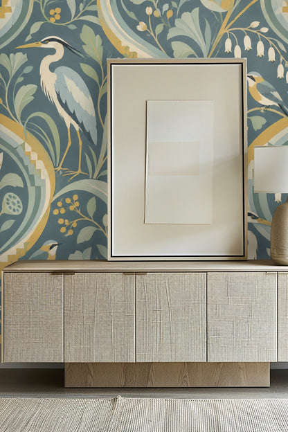 Close-up of a blue velvet couch against a wall covered in Duckegg Delta Drift Heron wallpaper